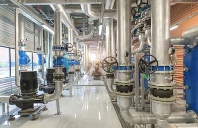 Pump room with blue pumps and insulated piping